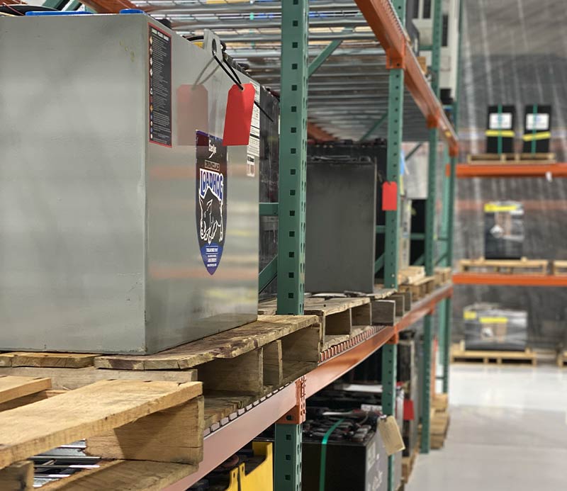 Forklift batteries stored on warehouse pallet racking. 