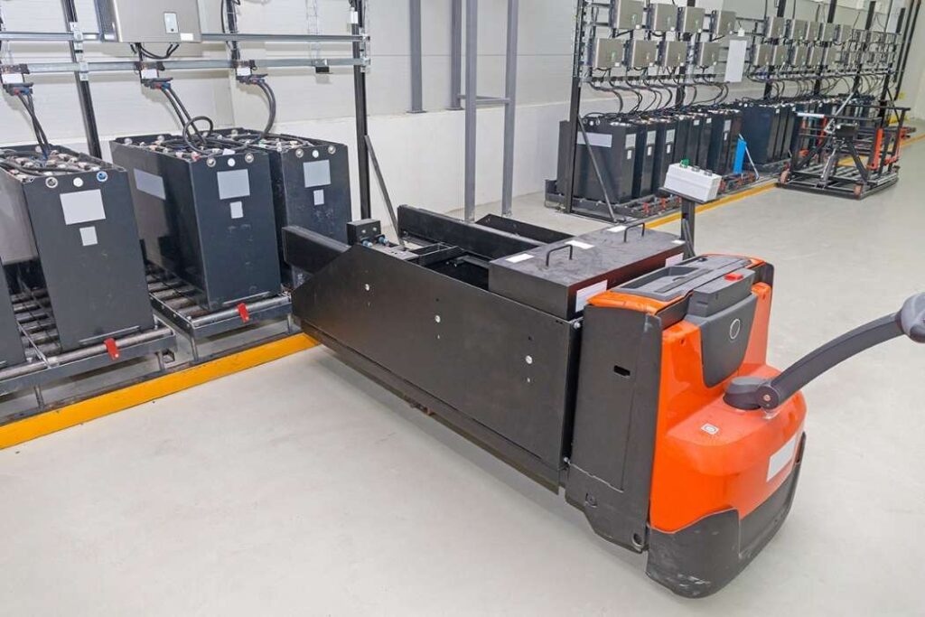 Pallet jack battery cart at industrial charging station.